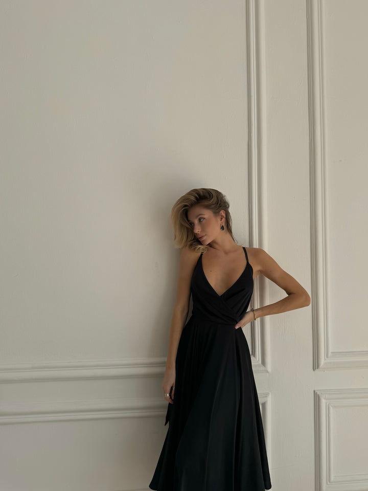 Side profile of black satin slip dress with elegant flowing midi silhouette