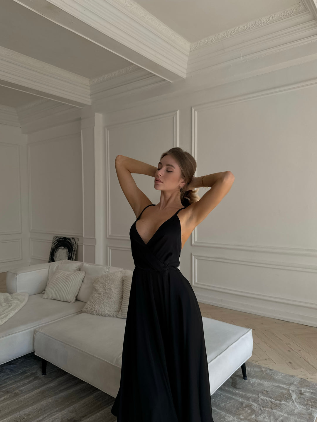 Woman wearing black silk slip midi dress for a formal evening event
