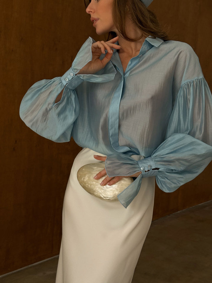 Model wearing ice blue semi-transparent collared shirt, relaxed fit and lightweight lyocell drape