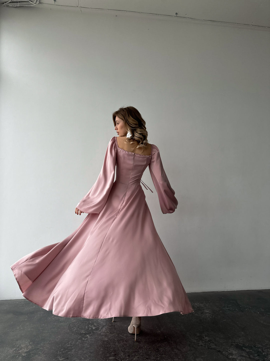 Flowing blush satin gown with a classic sweetheart neckline, bishop sleeves, and a floor-sweeping skirt. A gorgeous spring formal dress ensemble.