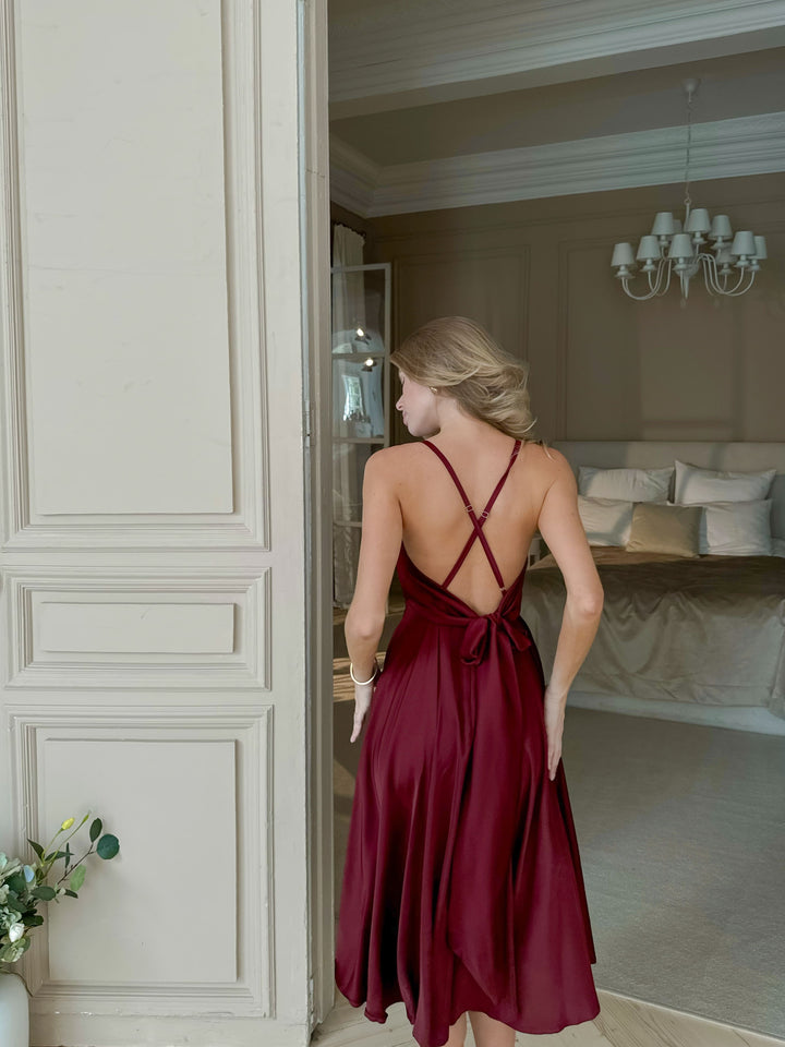 Burgundy satin slip midi dress with open back and criss-cross straps — skirt in movement, bridesmaid or date night look