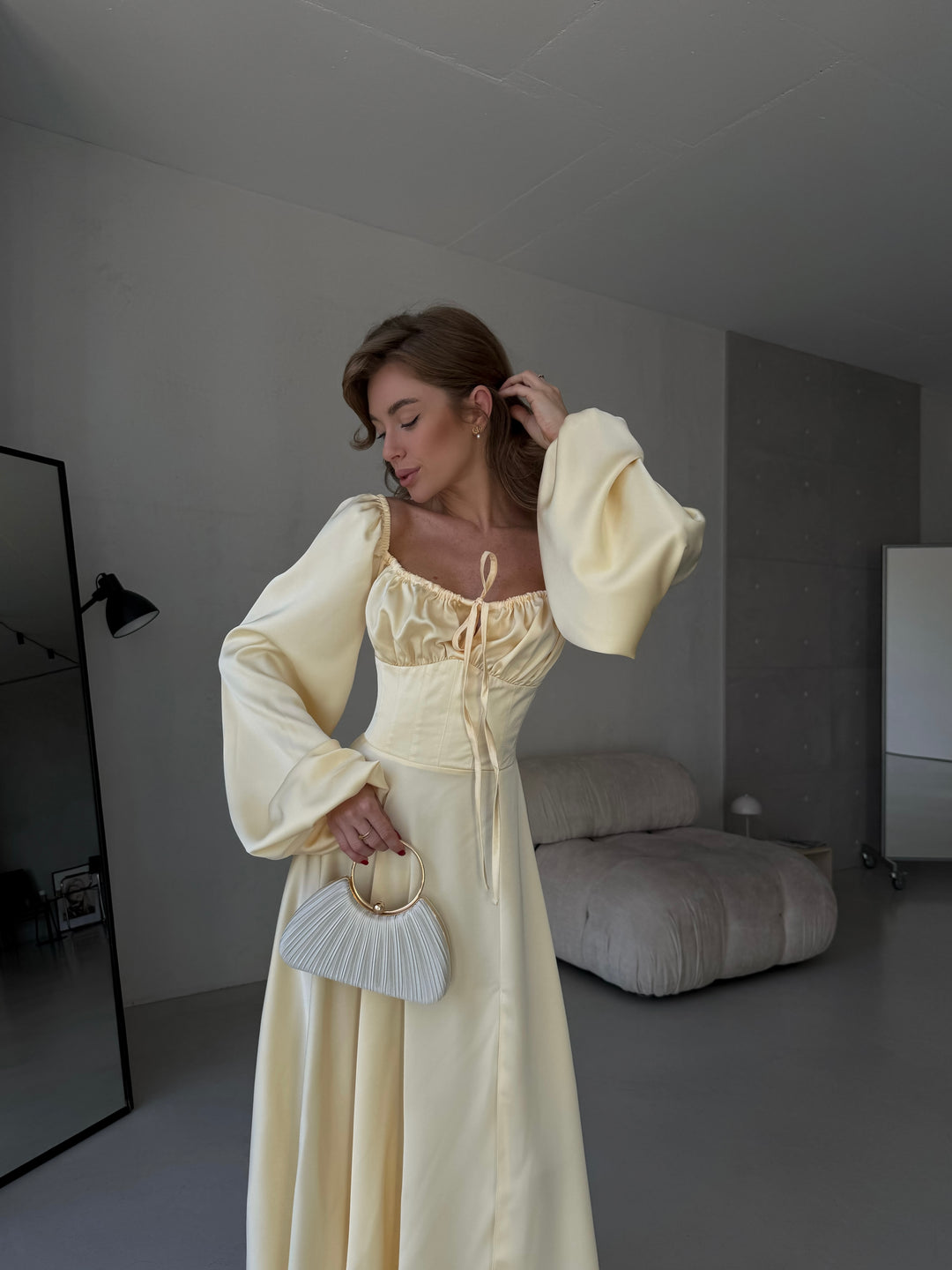 Floor-length satin maxi dress in butter yellow with a flattering sweetheart neckline and versatile draped sleeves. A refined option for a stylish date night outfit.