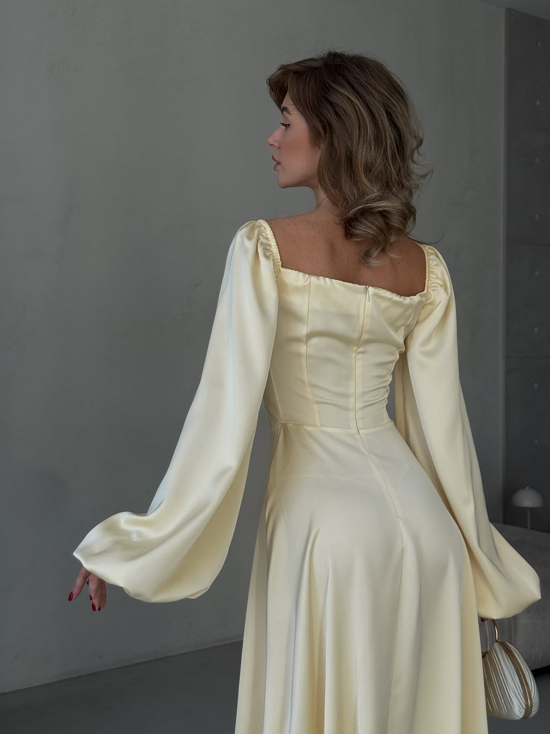 Elegant butter yellow satin gown with off-the-shoulder balloon sleeves and a dramatic high slit. A sophisticated choice for a Miami vacation outfit or formal event.