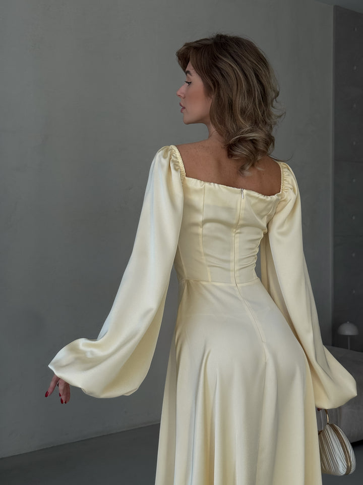 Elegant butter yellow satin gown with off-the-shoulder balloon sleeves and a dramatic high slit. A sophisticated choice for a Miami vacation outfit or formal event.