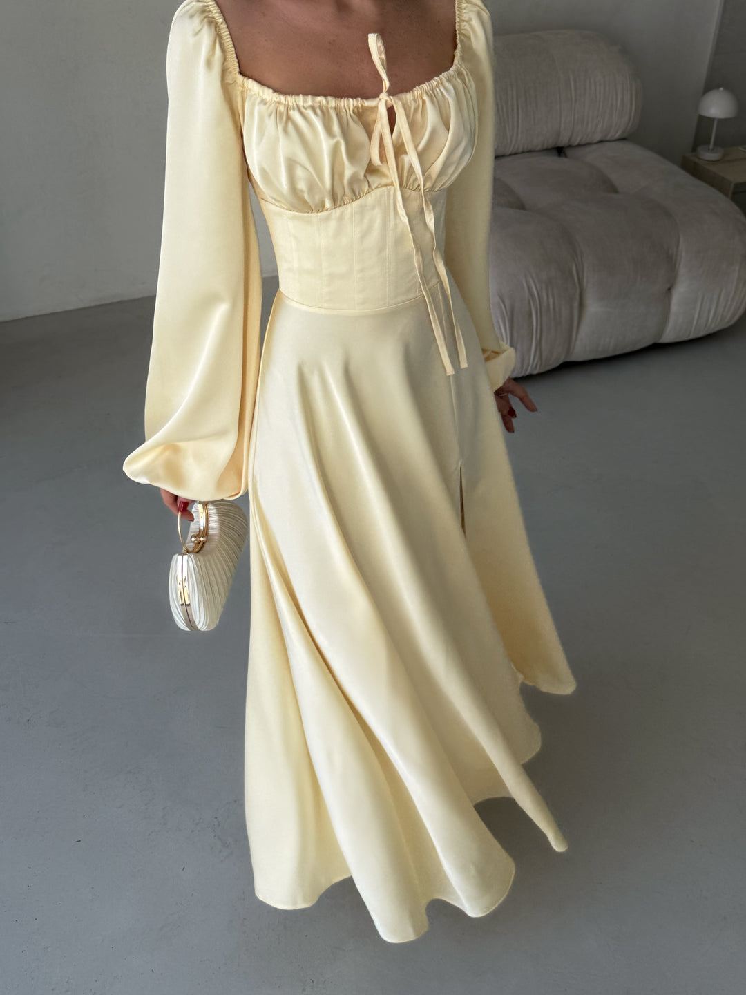 Beautifully draped butter yellow silk gown featuring a feminine sweetheart neckline and long balloon sleeves. A luxurious outfit choice for a formal spring gala.