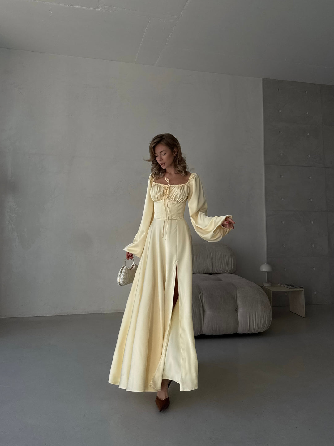 Flowing butter yellow satin formal dress with a sweetheart bust, long bishop sleeves, and a floor-sweeping skirt. A gorgeous choice for a spring bridesmaid dress.