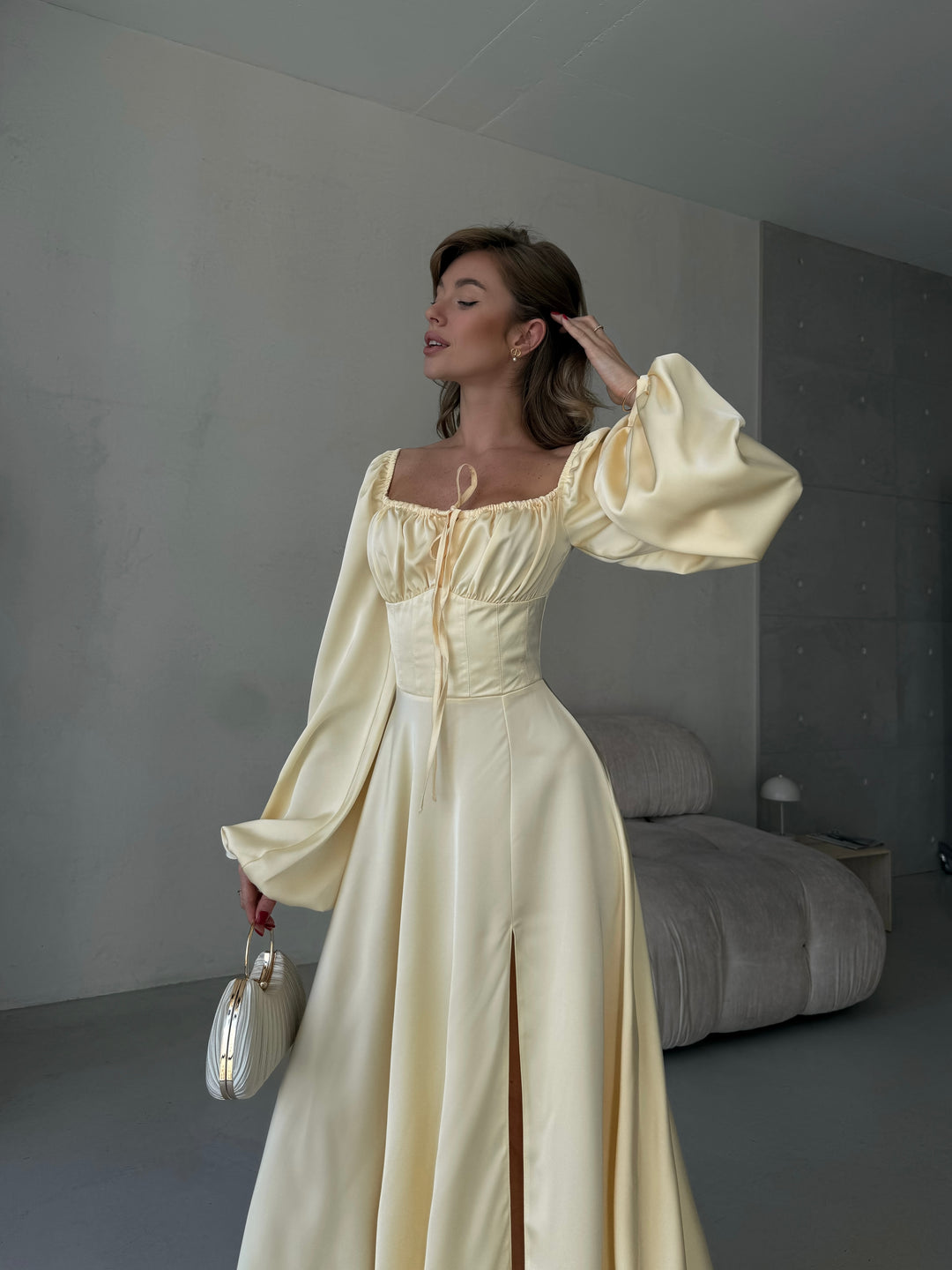 Flowing butter yellow silk maxi dress featuring a romantic sweetheart neckline, long bishop sleeves, and a high leg slit. Perfect for a spring wedding guest outfit.