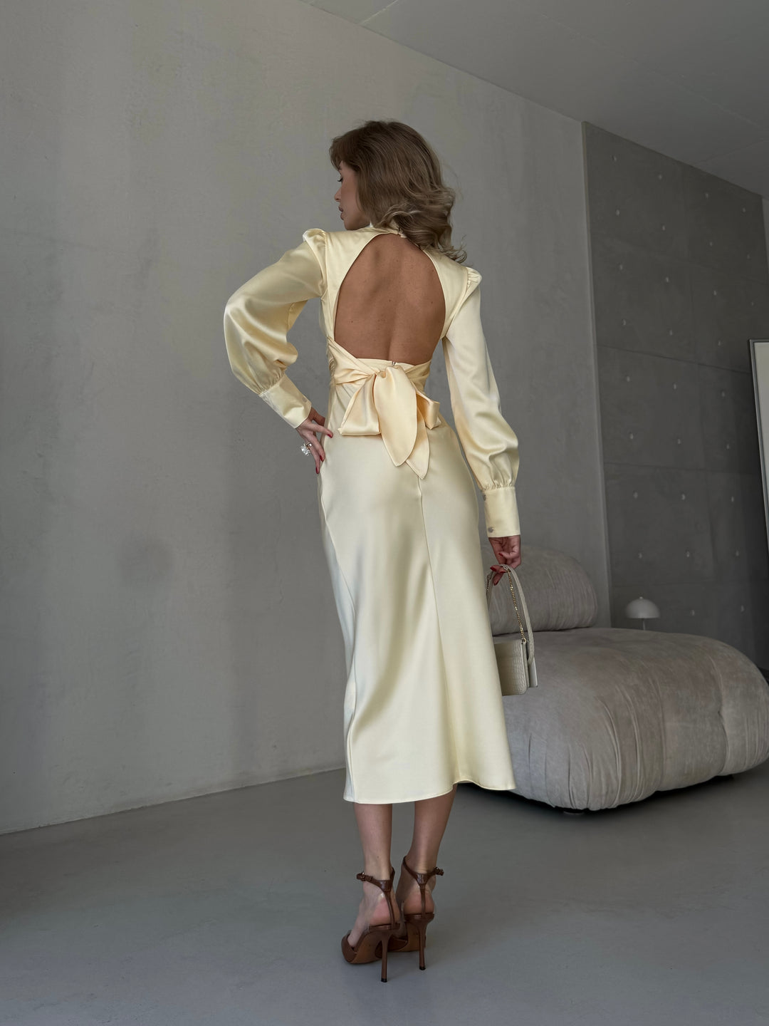 woman wearing a flowing butter yellow silk blend satin midi dress perfect for an upscale spring garden party