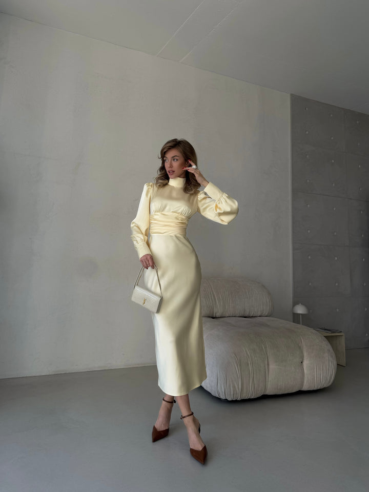 luxurious butter yellow silk midi dress with a bow tie back styled for an elegant tropical vacation dinner