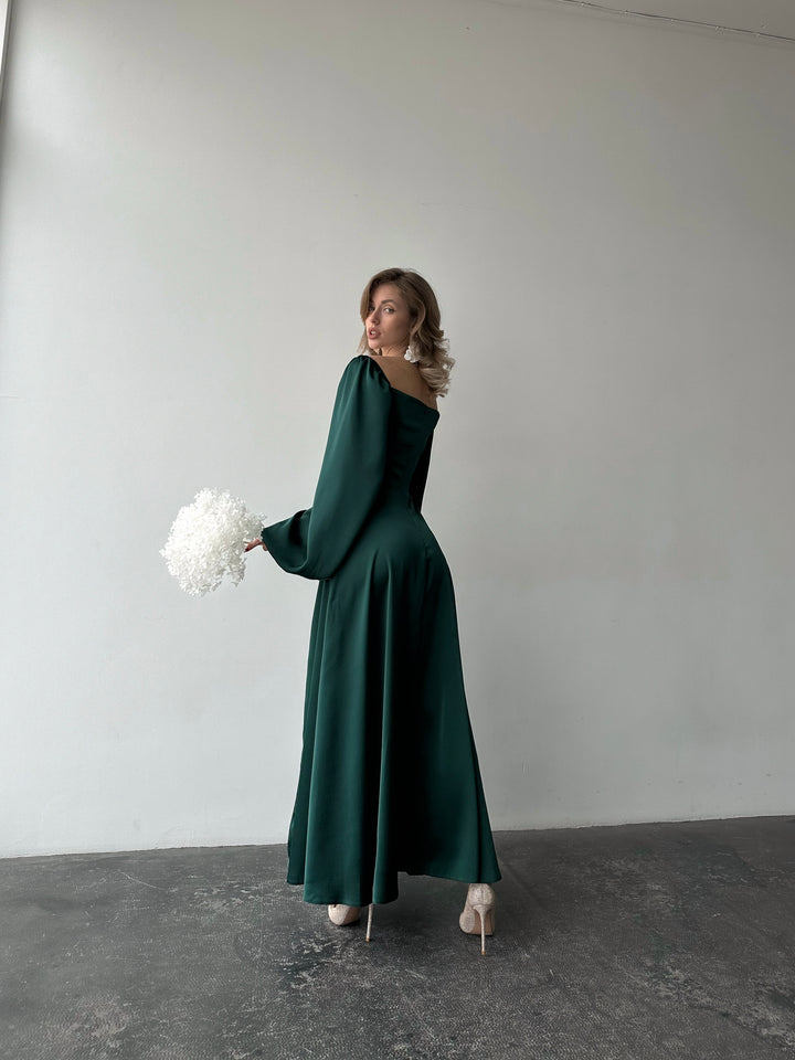 Dark green satin floor-length dress showcasing a sweetheart neckline and dramatic draped sleeves. A refined and modest silhouette perfect for a winter wedding guest.