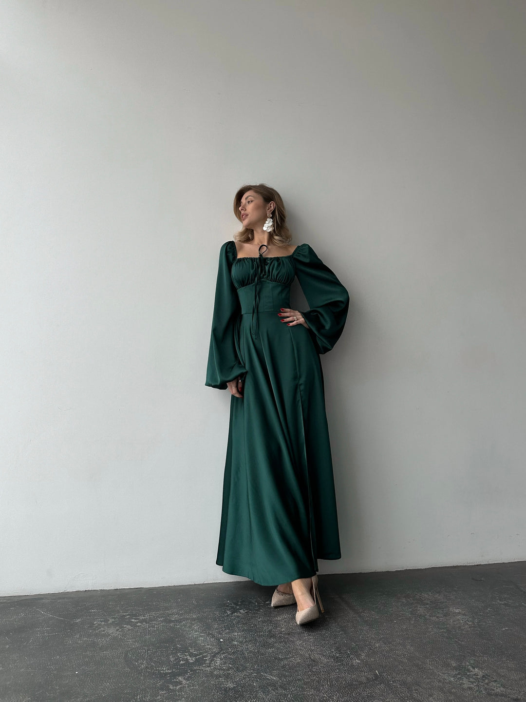 Flowing dark green satin gown with a classic sweetheart neckline, bishop sleeves, and a floor-sweeping skirt. A gorgeous formal event ensemble.