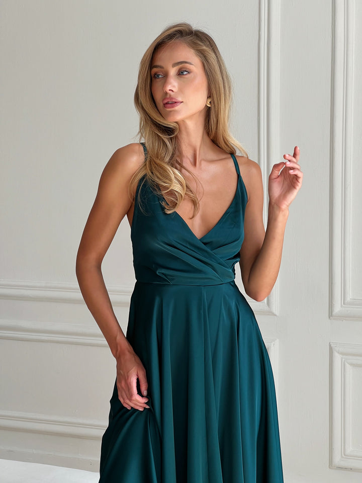 Emerald silk midi dress with bow closure — editorial styled shot