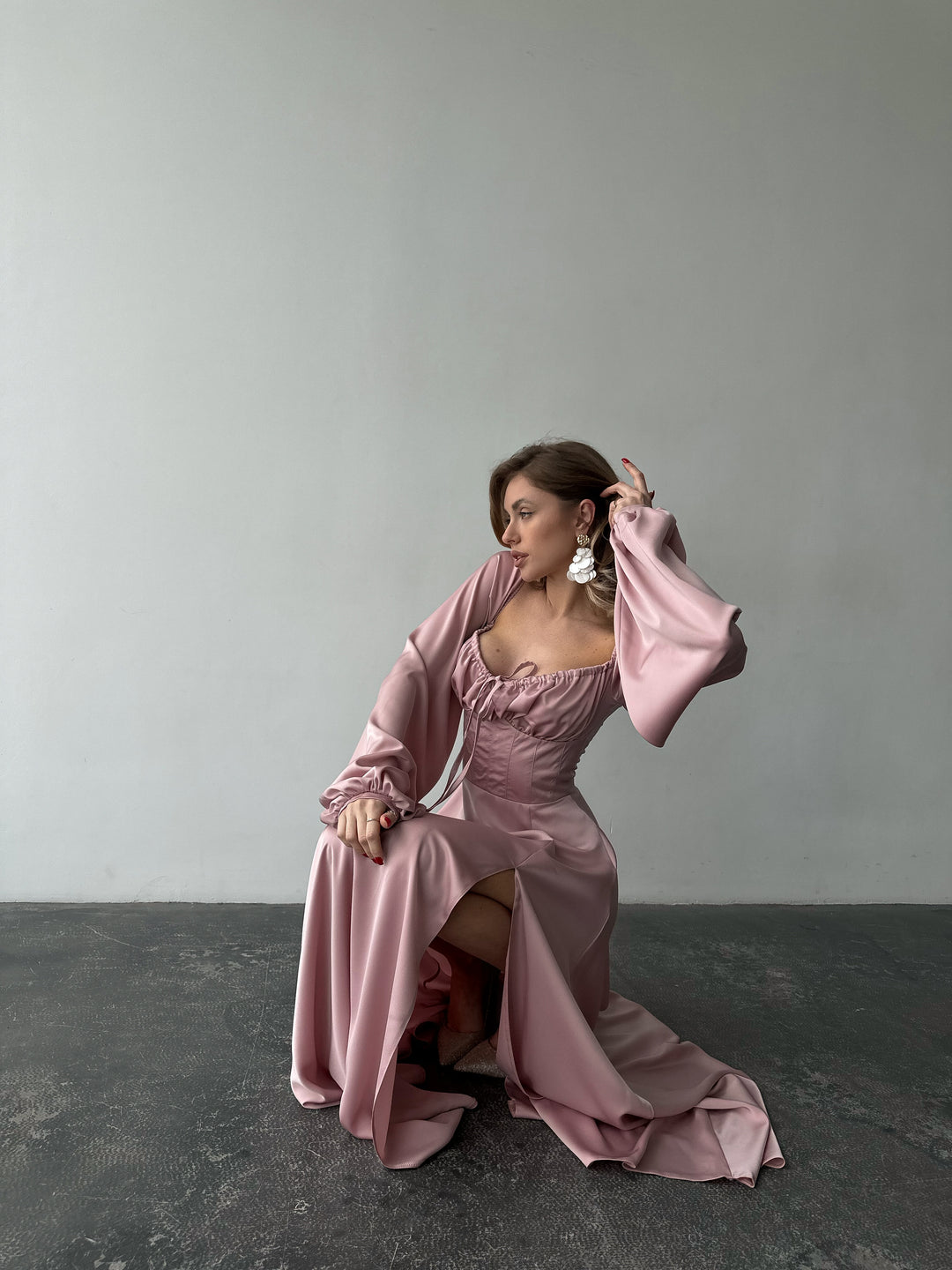Floor-length dusty pink satin dress with a flattering sweetheart neckline and versatile draped sleeves. A refined silhouette for a date night.