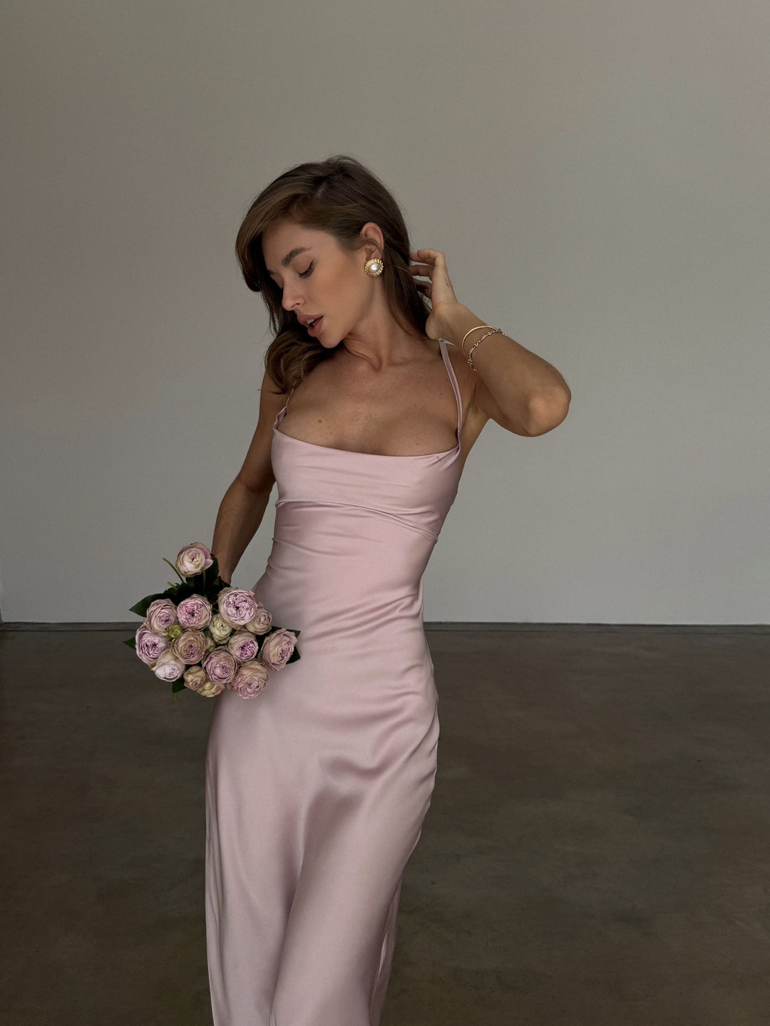 Dusty pink silk satin slip dress, front close-up of the draped cowl neckline, spaghetti straps and bias-cut bodice skimming the waist, styled with pearl earrings.
