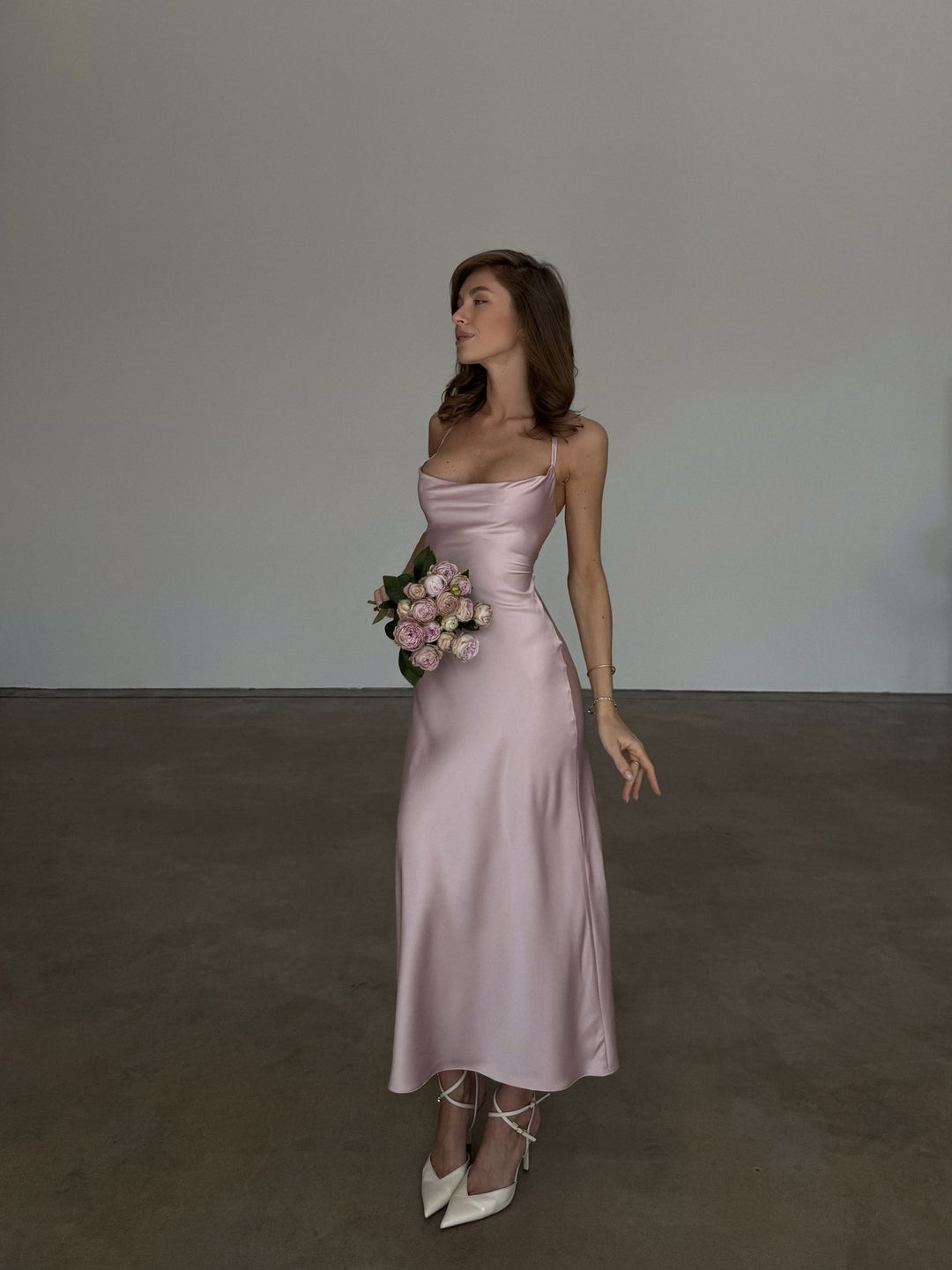 Dusty pink silk satin slip dress, full-length front view with cowl neckline and fluid bias-cut midi skirt that flares slightly at the hem, ivory strappy pumps.