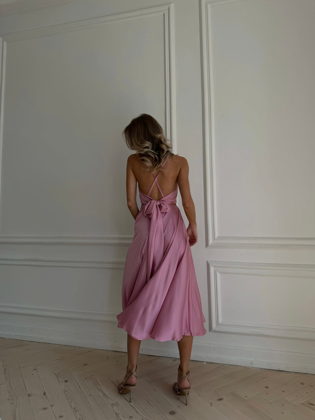 Dusty rose silk slip dress with bow closure — back detail editorial shot