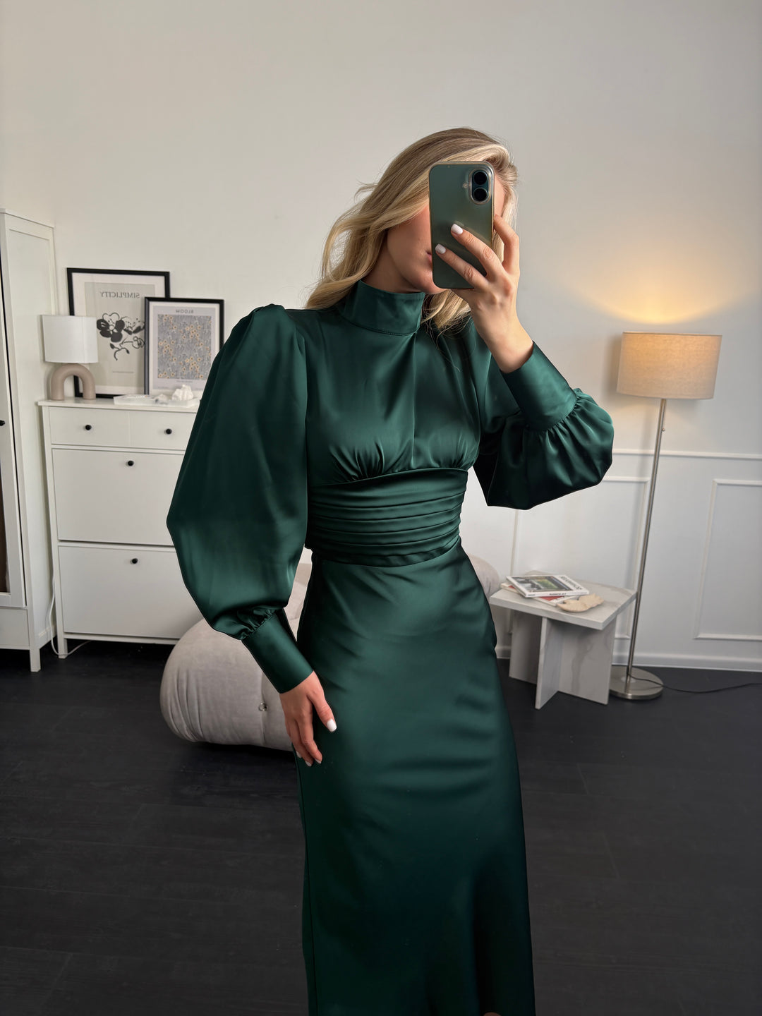 Three-quarter back view of emerald silk satin midi dress showing bow tie and fitted sheath shape