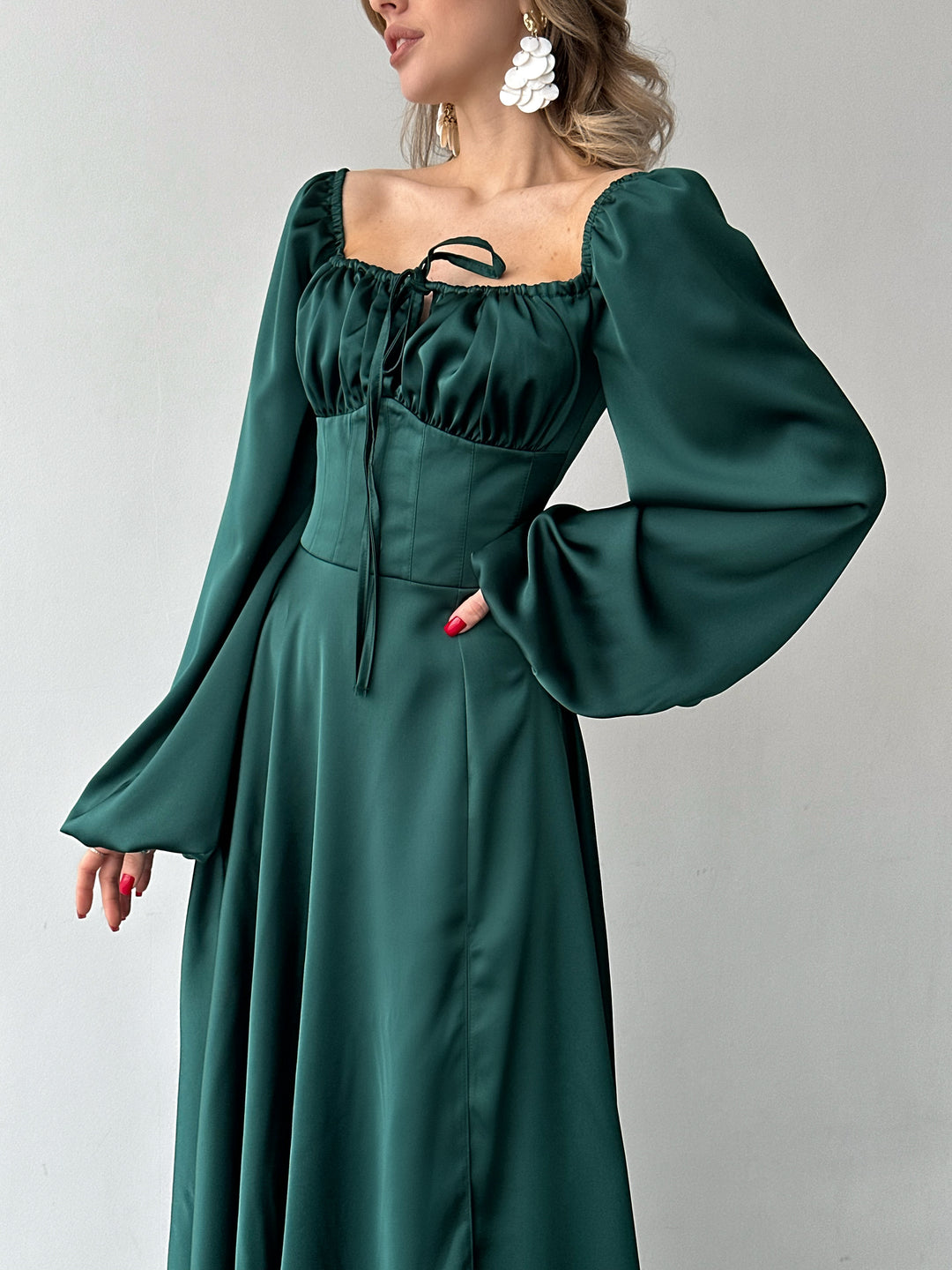 Floor-length rich green satin dress with a flattering sweetheart neckline and versatile draped sleeves. A refined silhouette for a winter formal.