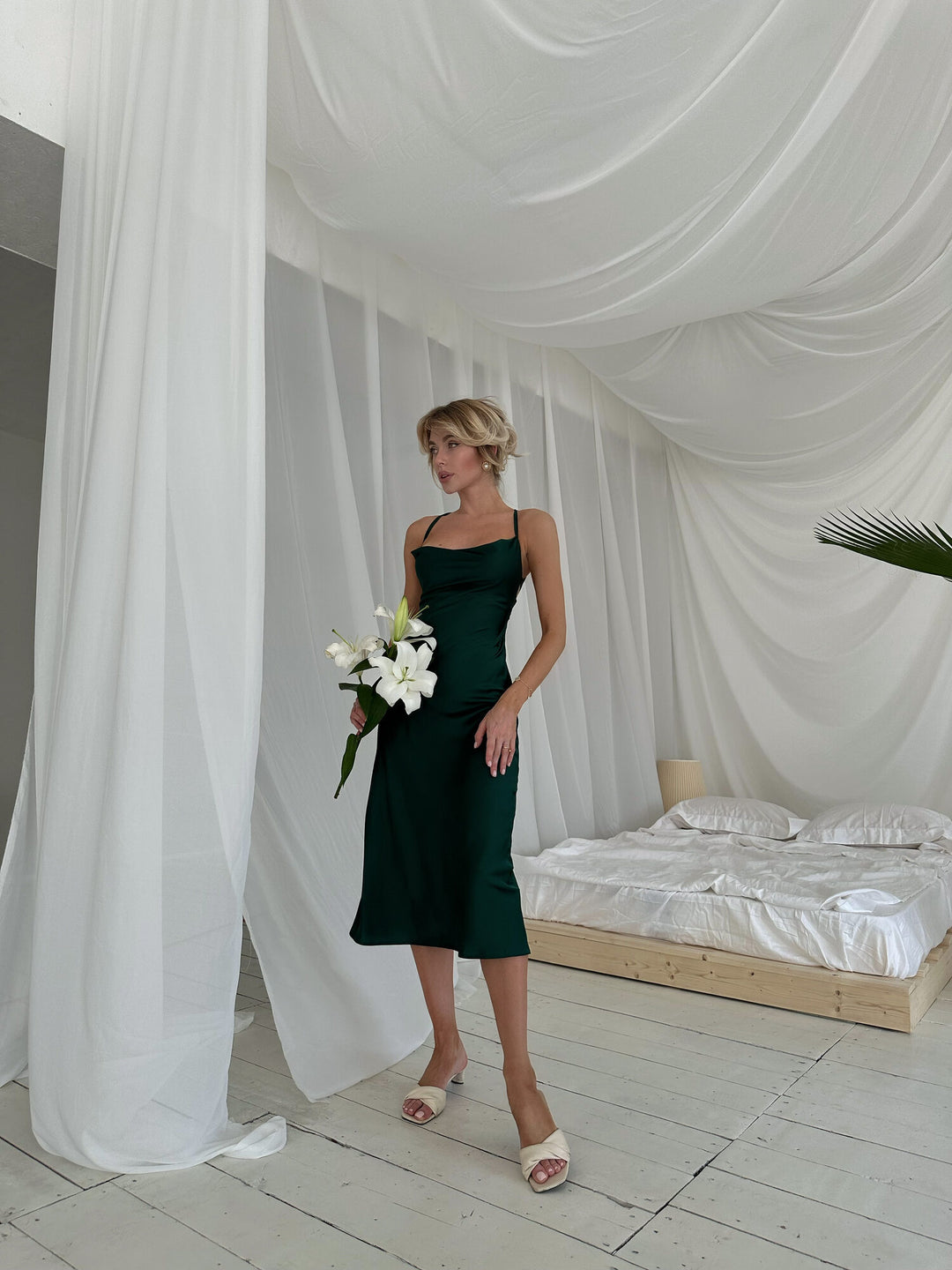 Front full length of emerald green satin slip dress. Cowl neckline