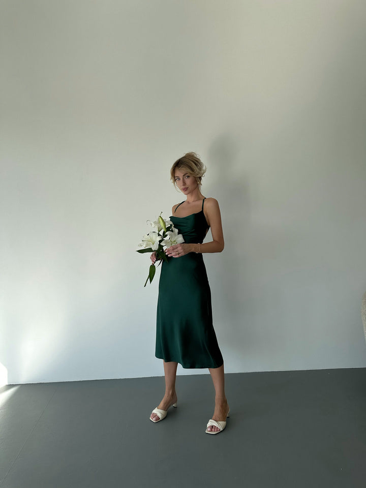 Emerald green satin slip dress full length on white backdrop. Cowl neckline
