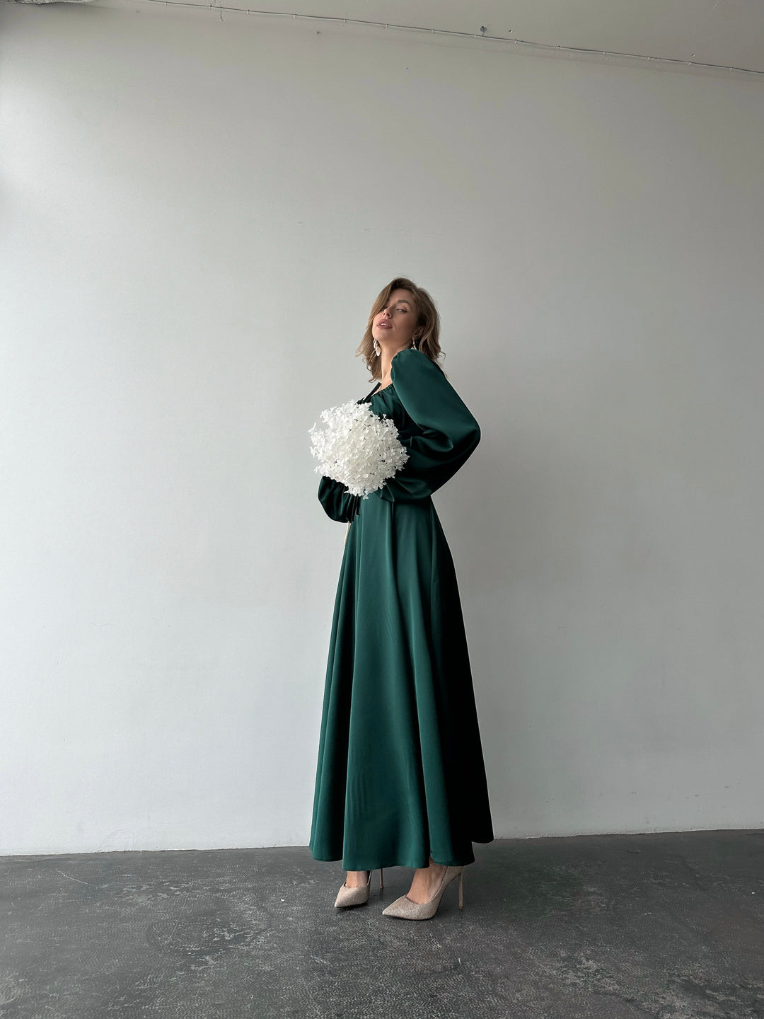 Flowing jewel-toned green silk-like formal gown with off-the-shoulder puff sleeves and a side slit. A stunning feminine look for a sophisticated Miami date night outfit.