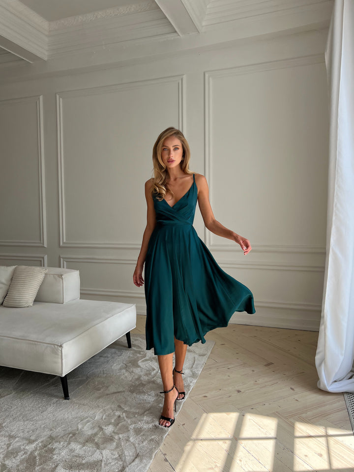 Back view of emerald green silk midi dress showing open back and bow tie closure