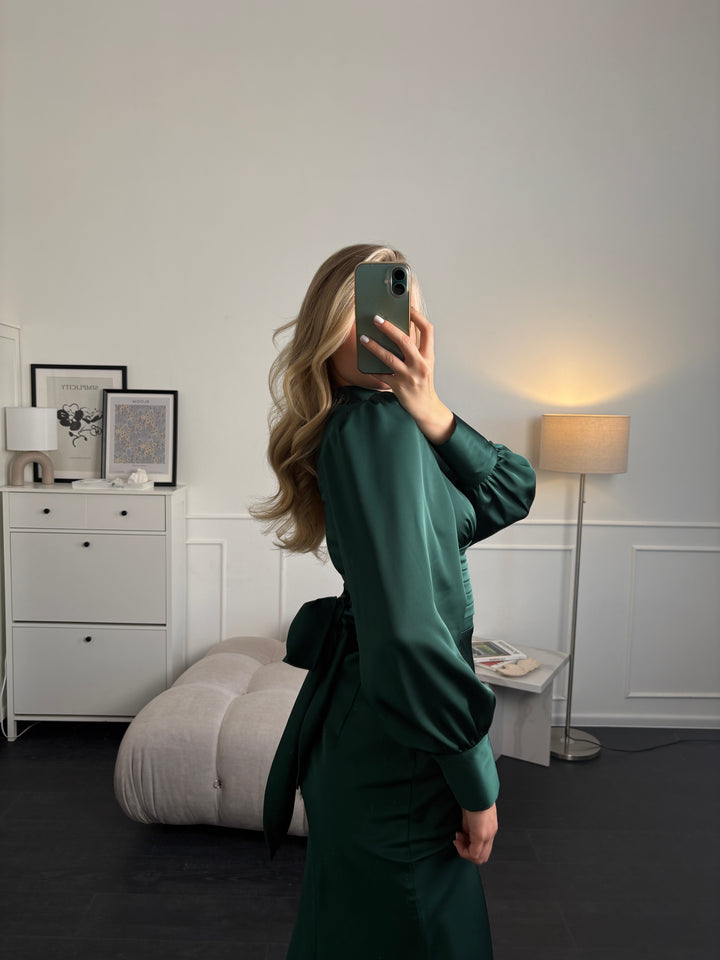 Bow tie back detail on emerald green long sleeve midi dress — functional satin bow with hidden zipper