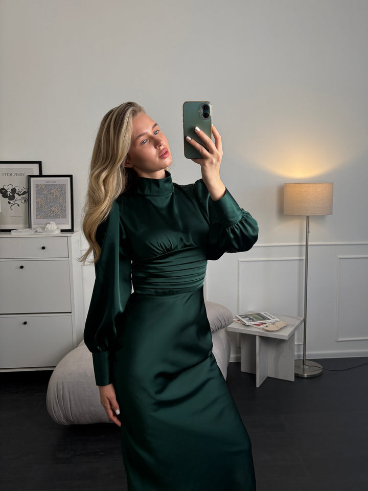 Full-length view of emerald silk satin dress with long sleeves, styled for a formal occasion