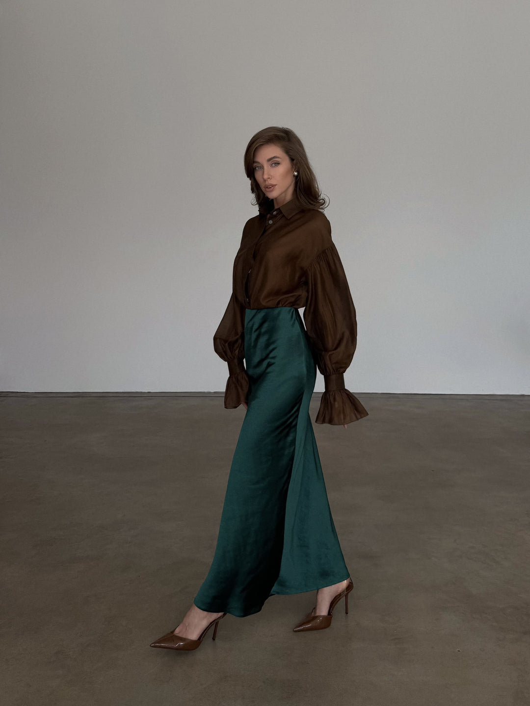 Side profile of the ankle-grazing forest green skirt highlighting the continuous bias-cut flow.
