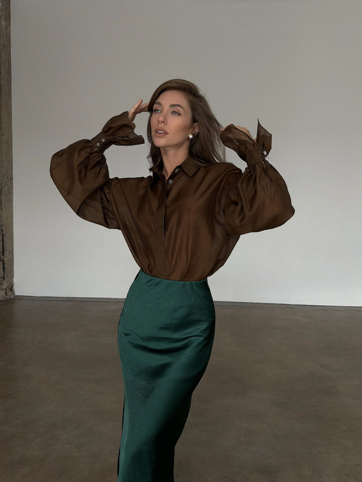 Mid-section side view showing the high waist placement of the dark green slip skirt.