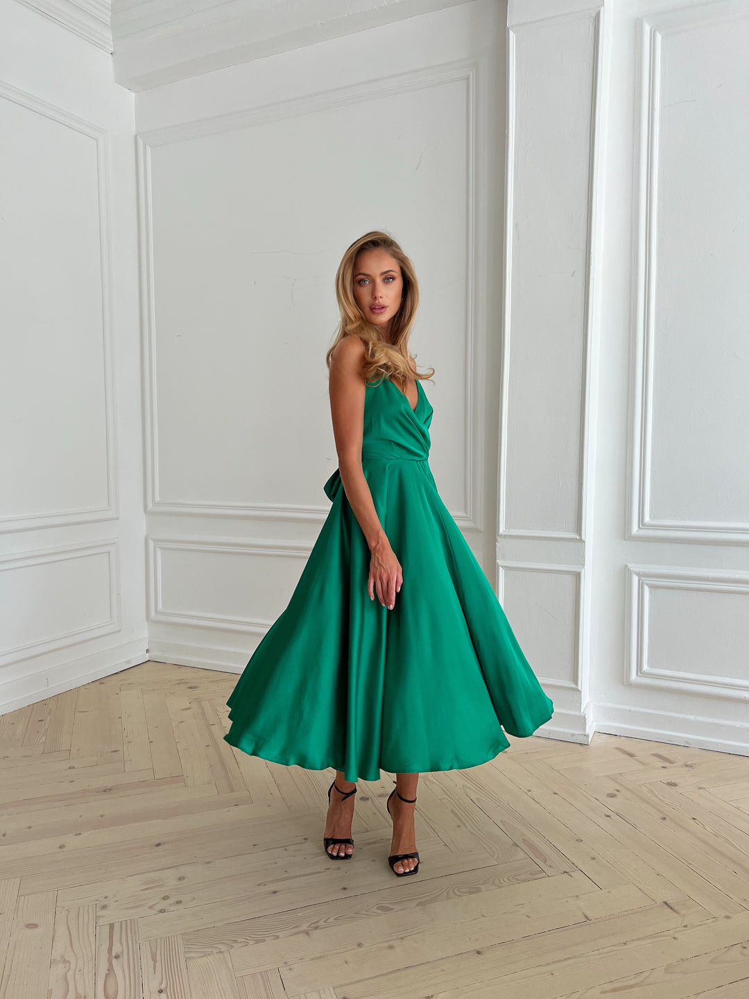 Side profile of bright green silk slip dress with flowing midi skirt