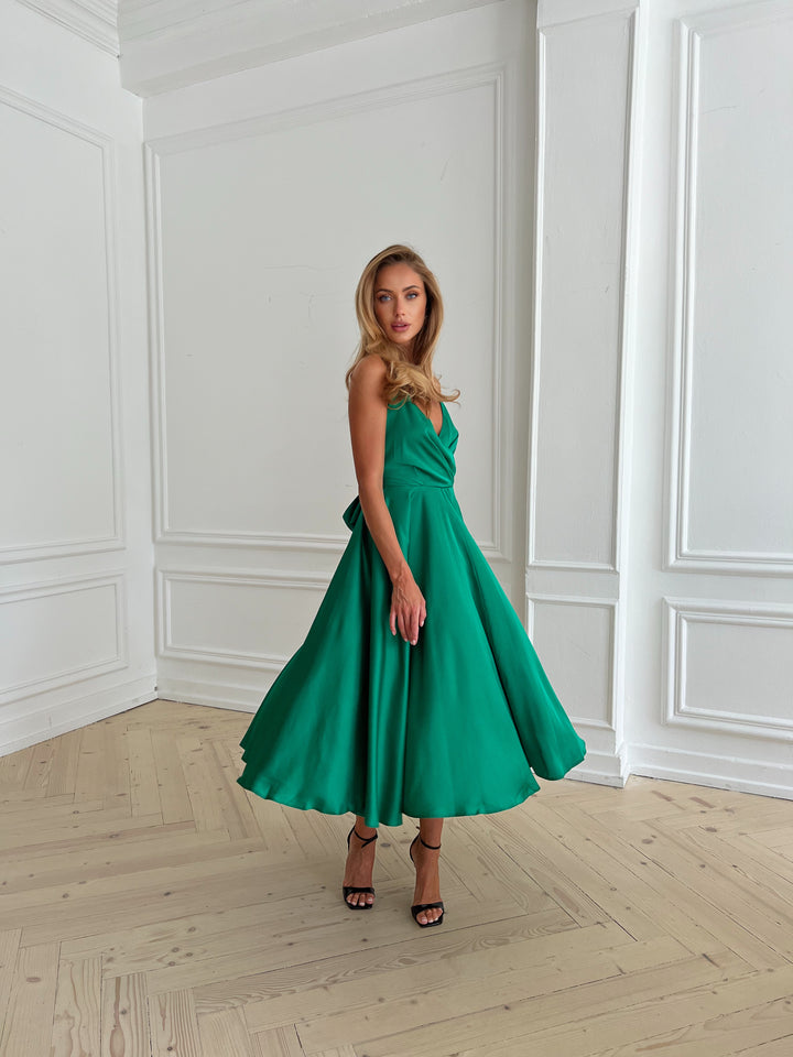 Side profile of bright green silk slip dress with flowing midi skirt