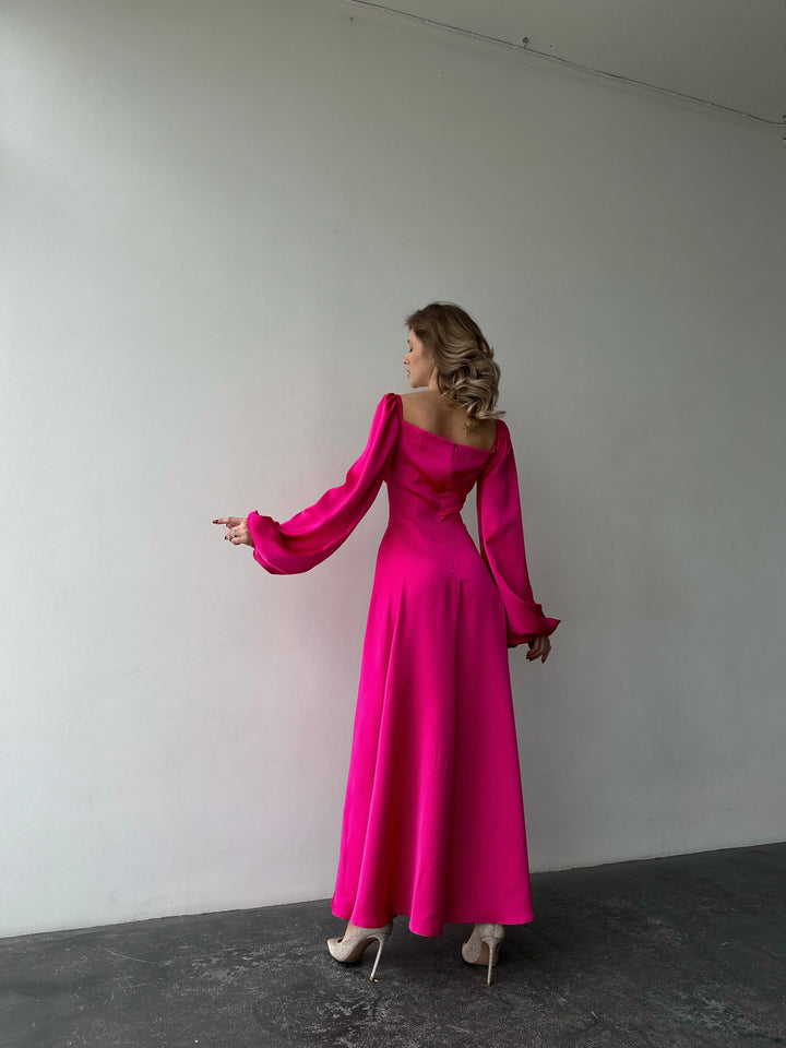 Bold bubblegum pink long-sleeve formal maxi dress made from silky satin. Features an elegant high leg slit, perfect for a chic summer wedding guest.