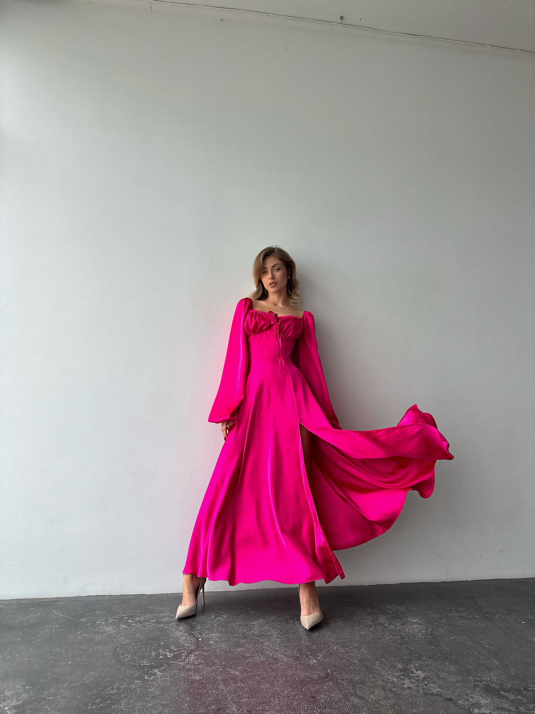 Long-sleeve hot pink silk-blend formal dress highlighting a fitted bodice and sweeping maxi skirt. Ideal for an upscale date night outfit in NYC.