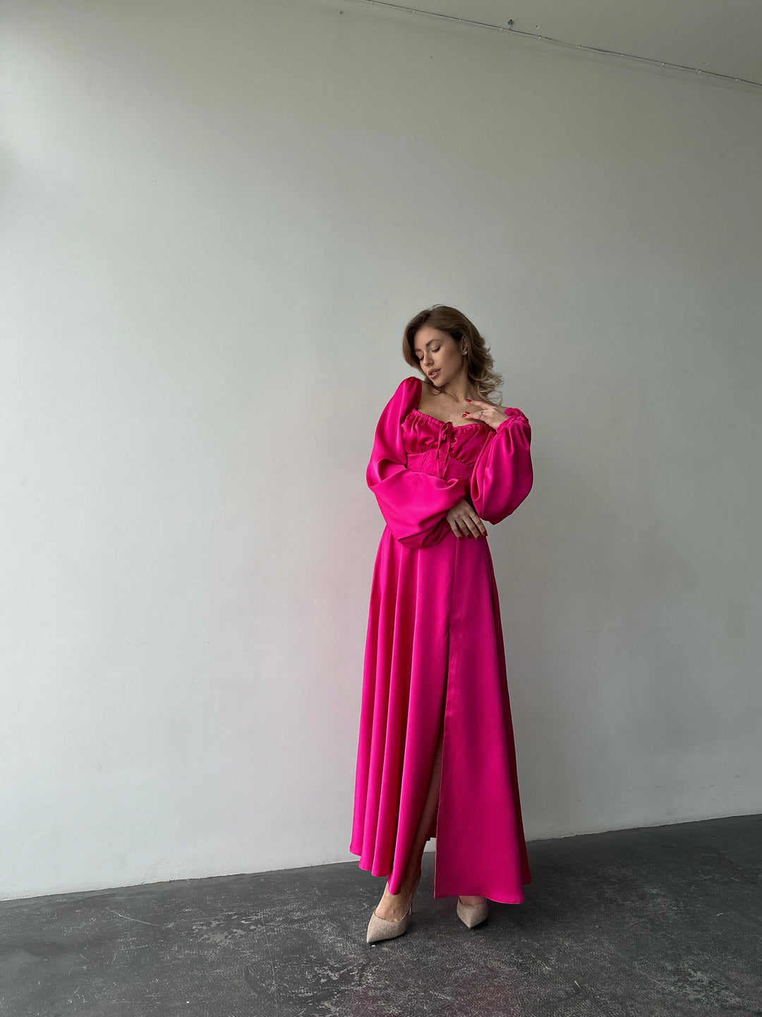 Beautifully draped hot pink silk dress featuring a feminine sweetheart neckline and long balloon sleeves. A luxurious outfit choice for a spring gala.