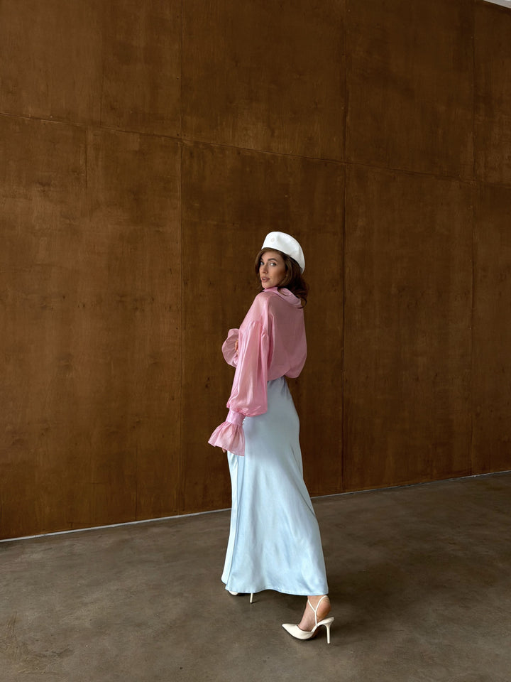 Model walking in ice blue satin midi skirt showing the fluid movement of the satin fabric, the A-line shape swaying naturally, against a white studio backdrop