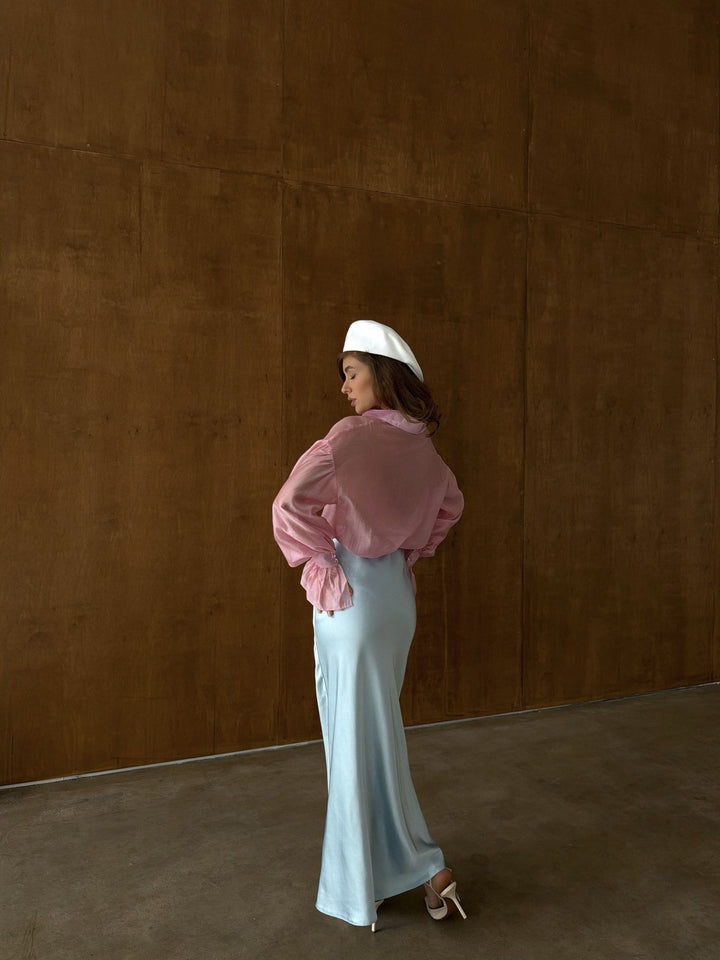 Lower body detail of ice blue satin midi skirt showing the mid-section drape from the elastic waist through the hip area to below the knee