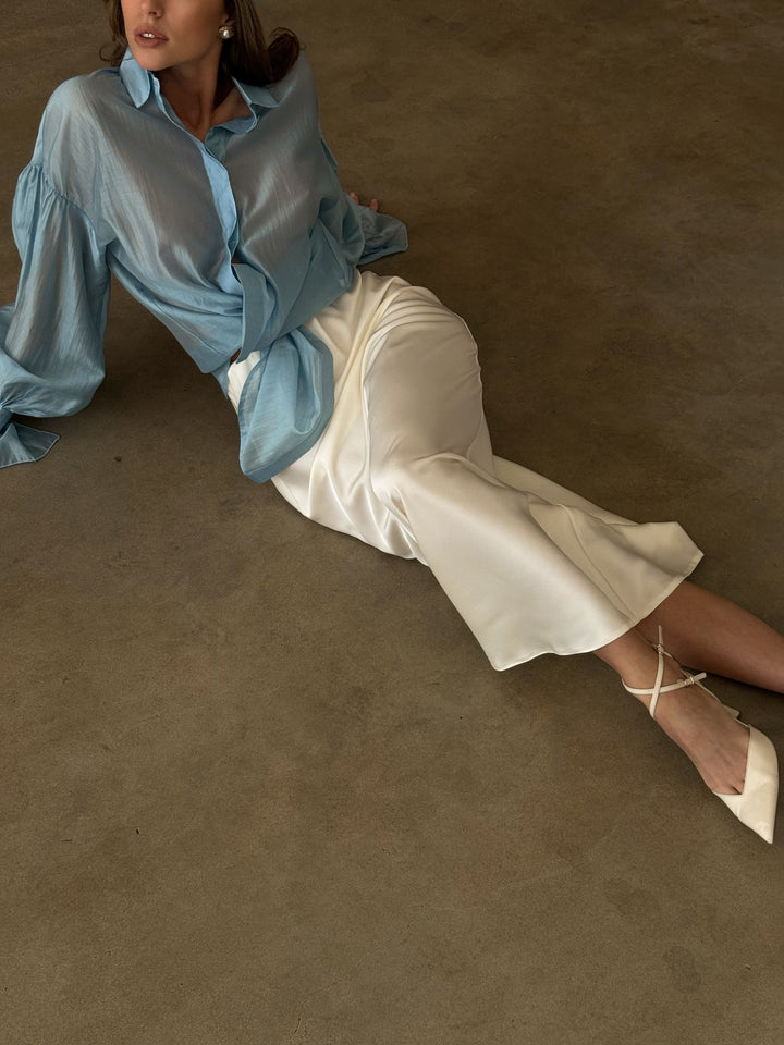 Ivory satin skirt with a fluid hem and subtle shine.
