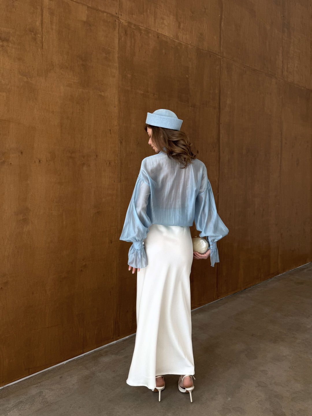 Back view of the ivory satin skirt with subtle sheen and smooth texture.