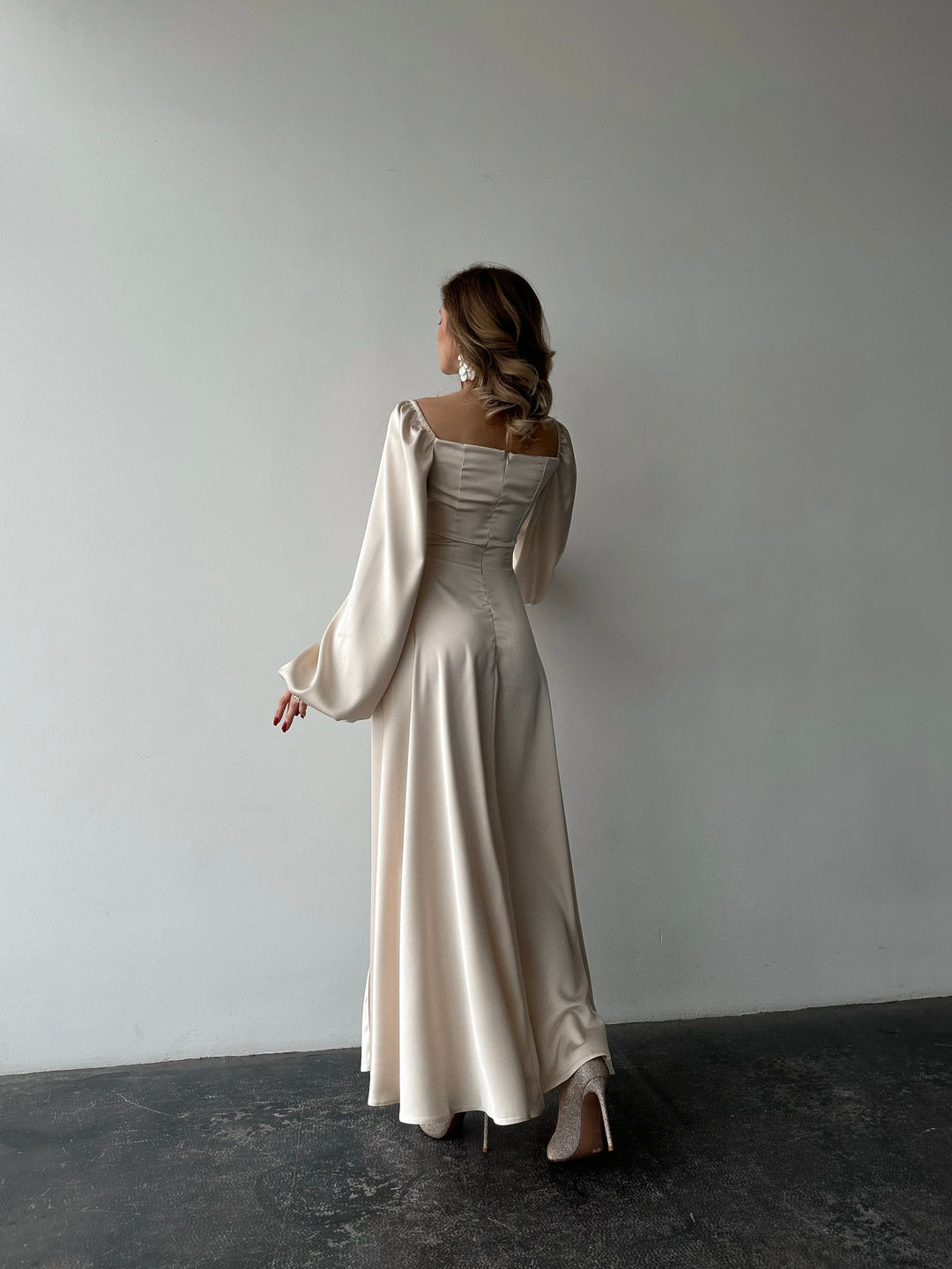 Ivory silk satin maxi dress back view — bishop sleeves and floor-sweeping skirt. Sleek, elegant silhouette. Perfect for brides, elopements, bridal photoshoots, and formal evening events.