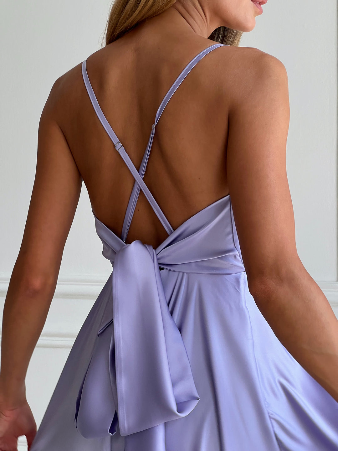 Back view of lavender silk midi dress with open back and bow tie closure