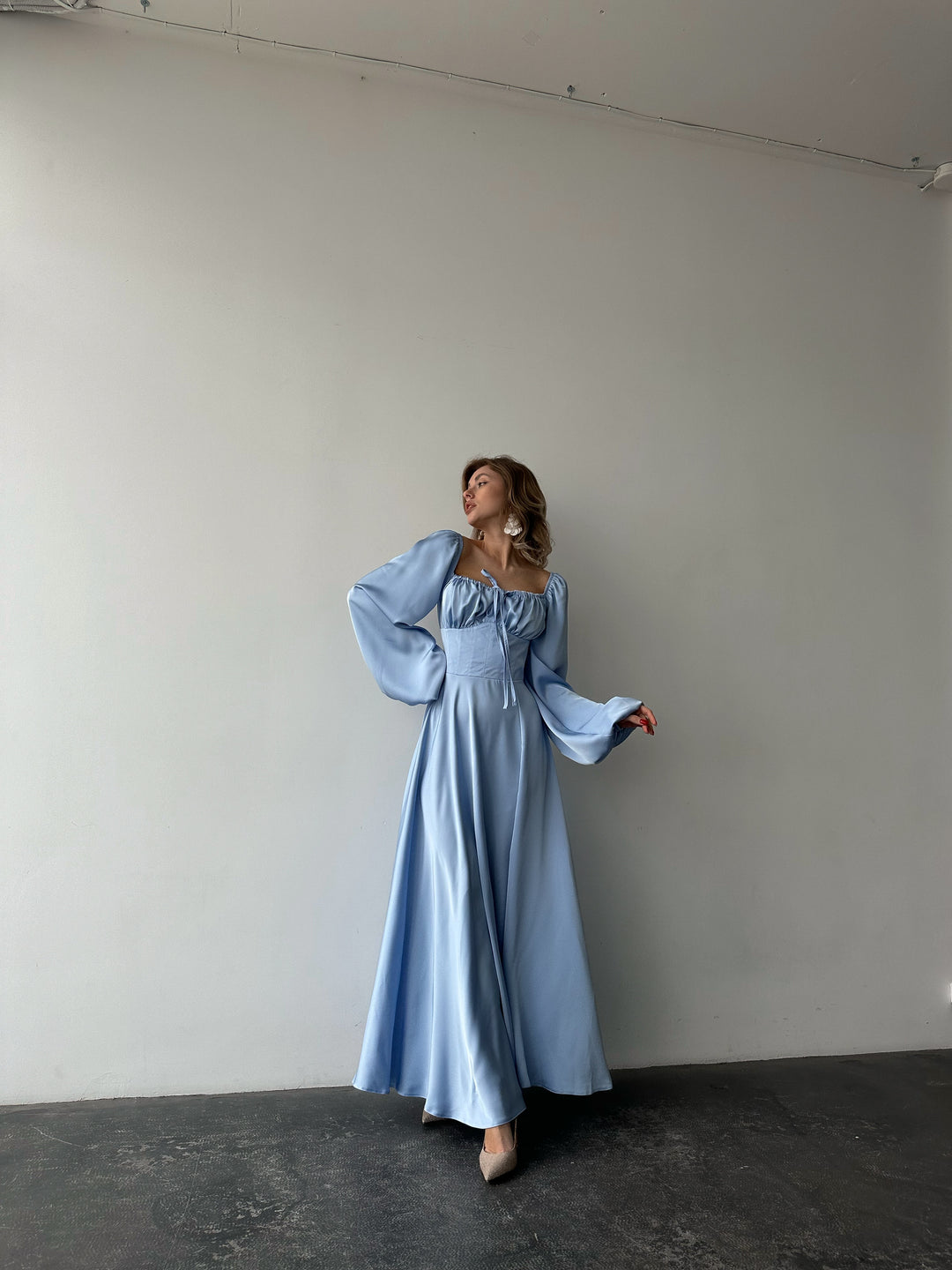 Flowing light blue satin gown with off-the-shoulder balloon sleeves and a high slit. A modern feminine option for a chic Miami vacation dress aesthetic.