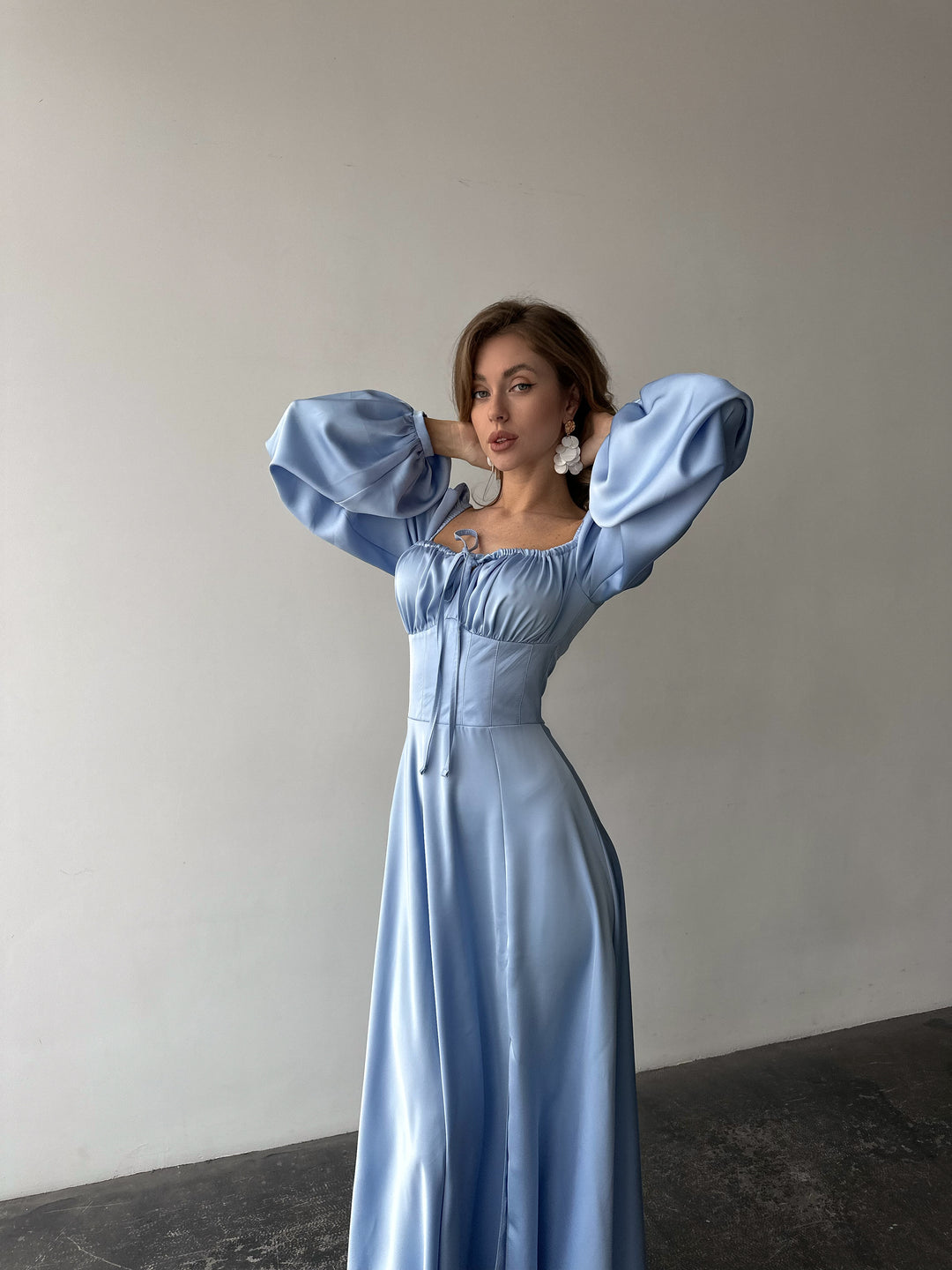 Premium ice blue silk-like maxi dress featuring delicate draped sleeves and a leg slit. An elegant outfit choice for an upscale summer resort vacation.