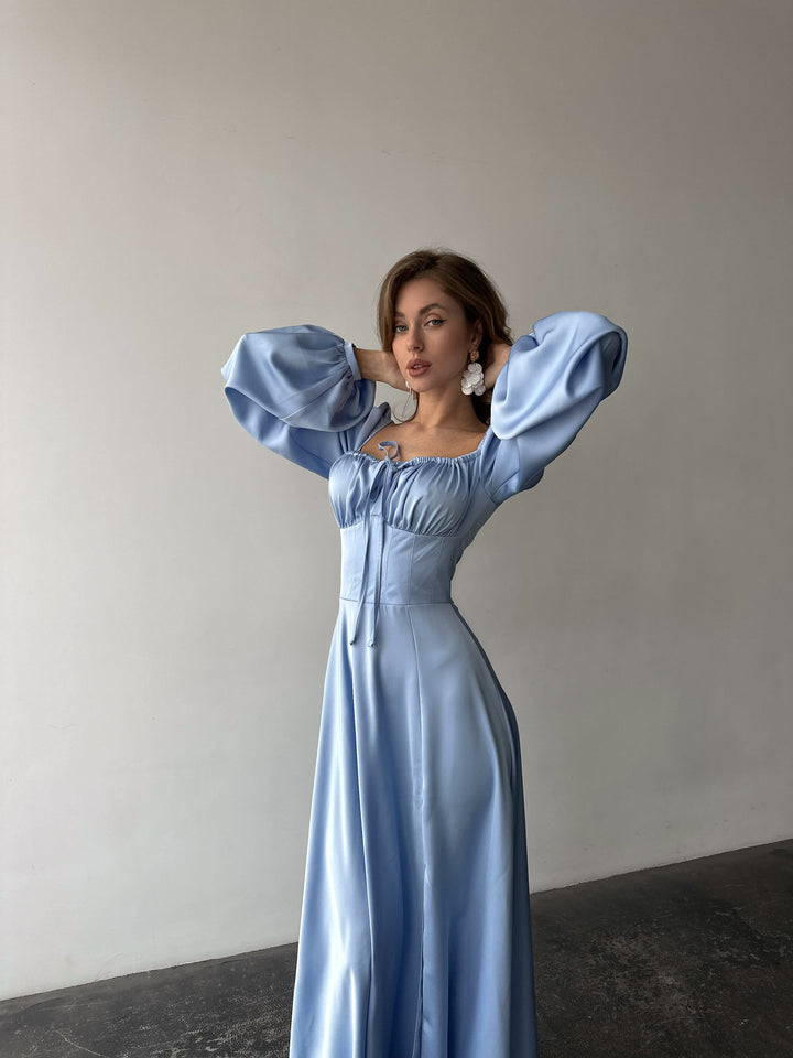 Premium ice blue silk-like maxi dress featuring delicate draped sleeves and a leg slit. An elegant outfit choice for an upscale summer resort vacation.