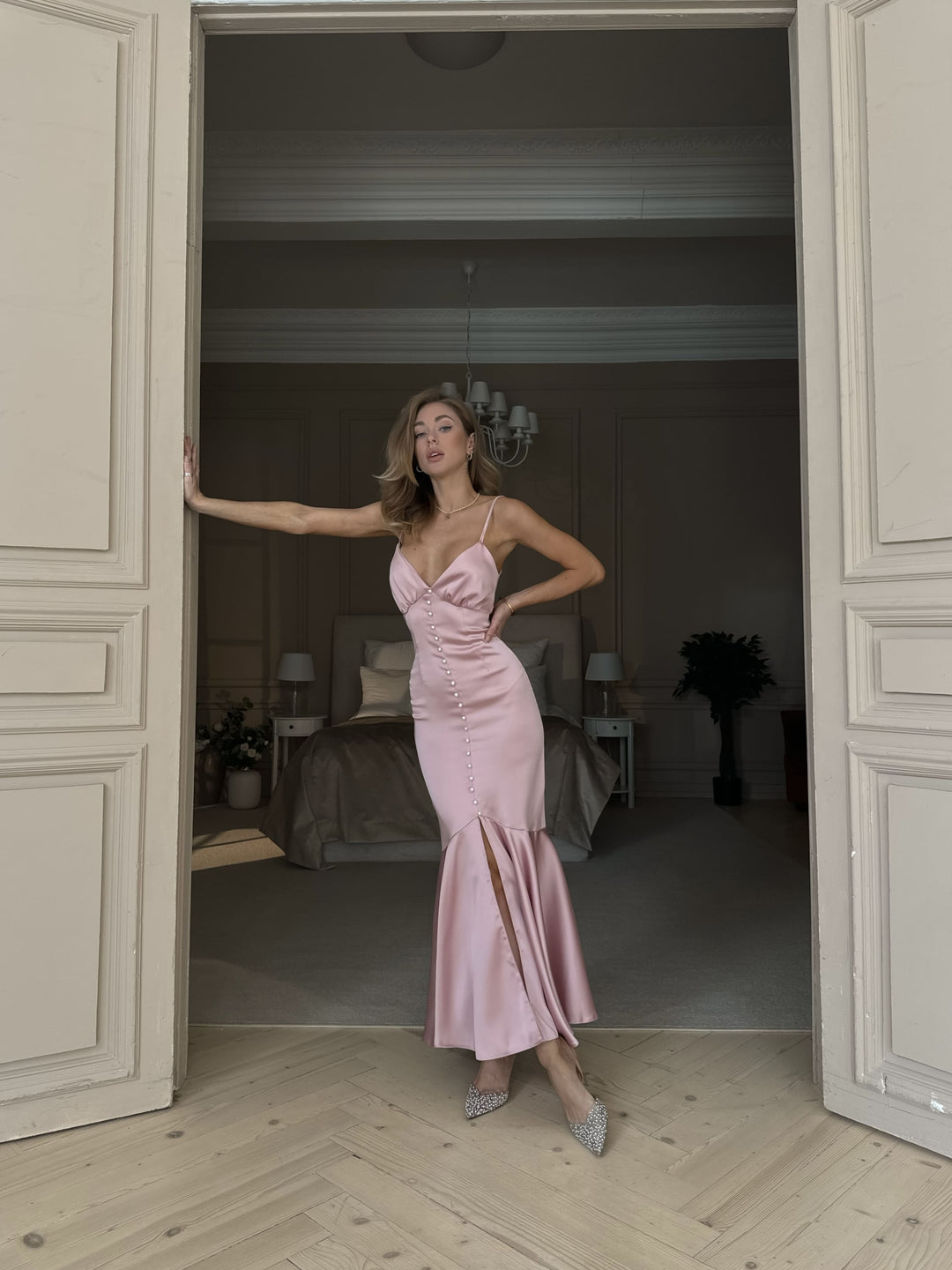  Light pink satin dress with pearl buttons and mermaid skirt — standing in doorway with white trim