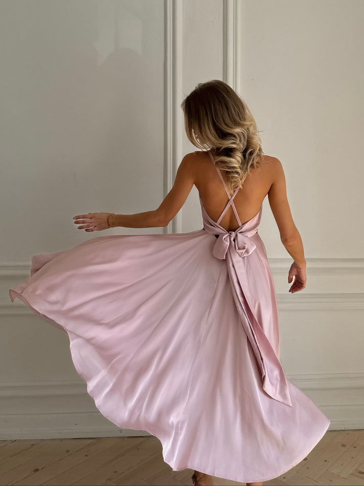 Light pink silk slip midi dress with deep V-neck and open bow back — front view