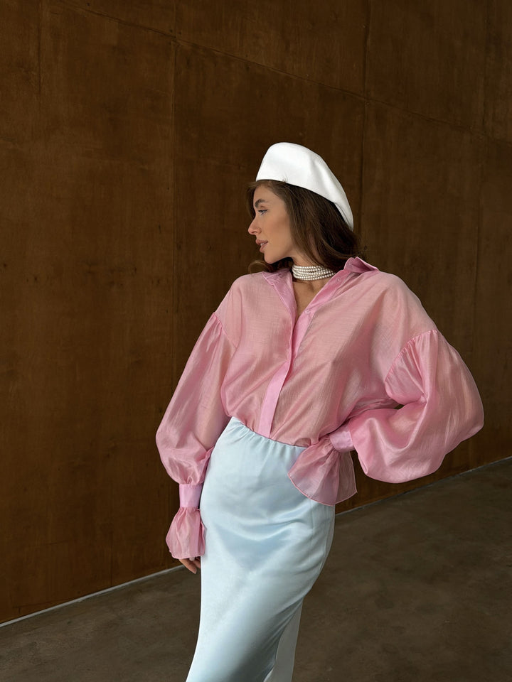 Close-up of the bubblegum pink woven lyocell fabric showing translucent texture and smooth finish