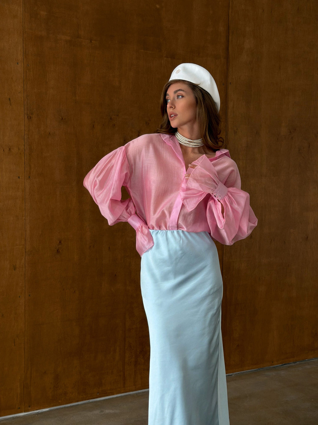 Model in motion wearing pink semi-transparent collared shirt showing lightweight drape and breathable fabric
