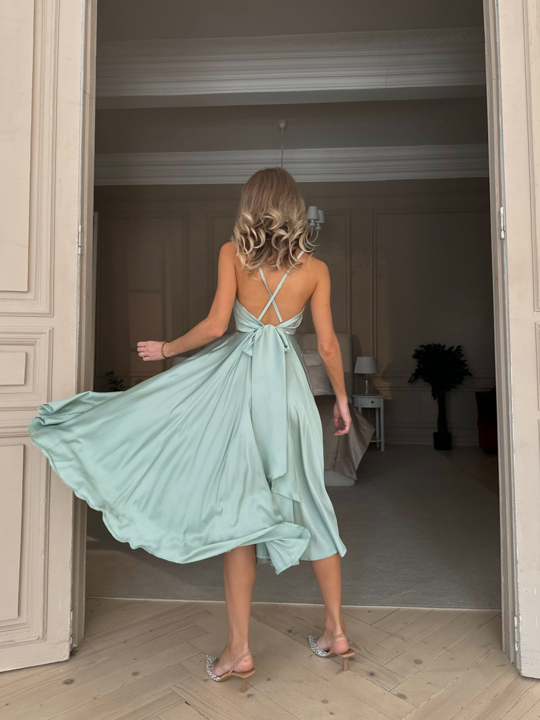 Pistachio green silk slip dress — fabric drape and texture close up