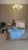 Light blue silk slip midi dress with deep V-neck and open back modelled in motion — EvolveUA